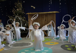 Dziewczynki przebrane za aniołki podczas tańca z szarfami