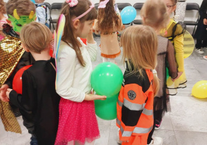 Przebrane dzieci tańczą z balonem