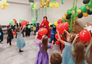 Przebrane dzieci tańczą z balonami