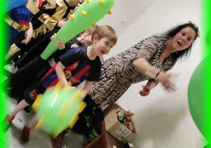 Dzieci podczas konkursu z maczugami: celowanie papierowymi kulami do groty