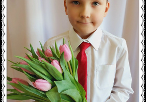 Chłopiec trzyma różowe tulipany.