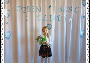 Dziewczynka trzyma różowe tulipany. W tle napis Dzień Babci i Dziadka.
