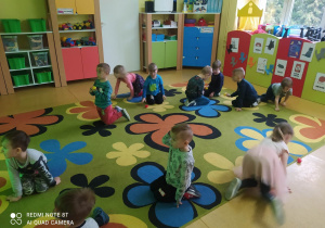 Dzieci na dywanie chodzą jak kotki i bawią się piłeczkami