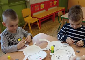 Dzieci wykonują koty z papierowych talerzyków i kolorowego papieru