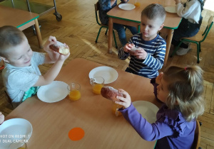 Dzieci jedzą pączki