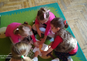 Dzieci układają puzzle na których jest pączek