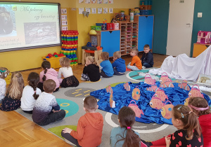 Dzieci oglądają film edukacyjny o niedźwiedziach.
