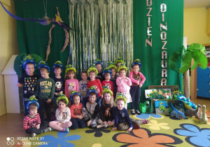 Zdjęcie grupowe na tle dekoracji z okazji Dnia Dinozaura