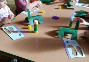 Dzieci wykonują samodzielnie papierowe dinozaury