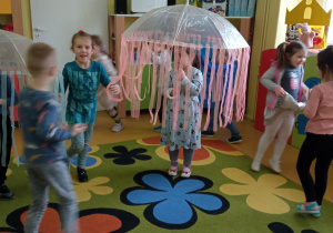 Dzieci tańcza przy piosence z filmu "Deszczowa piosenka".