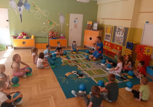 Dzieci uczestniczą w zajęciach sportowych z piłką.
