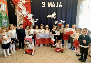 Dzieci z grupy 5, na tle dekoracji z okazji obchodów 3 Maja