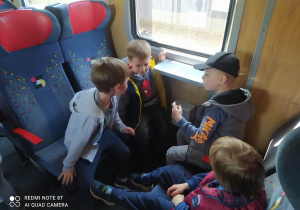 Chłopcy siedzą w przedziale pociągu