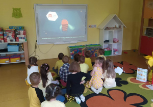 Dzieci oglądają film edukacyjny o pszczołach