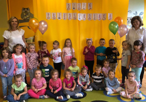 Zdjęcie dzieci z panią Olą i Agnieszką na tle napisu Dzień Przedszkolaka