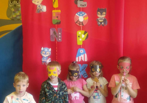 Dzieci natle dekoracji w maskach superbohaterów.