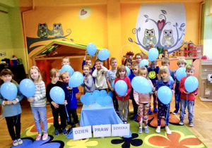 Zdjęcie grupowe z niebieskimi balonami.