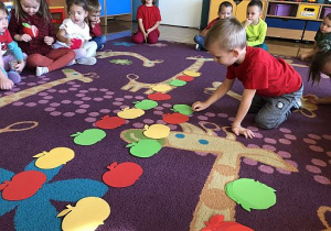 Dzieci układają rytmy z jabłek.