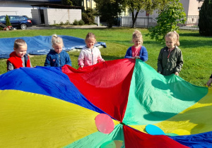 Dzieci falują kolorową chustą.