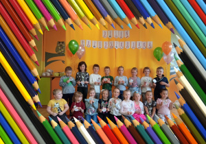 Grupa dzieci w ramce z kolorowych kredek.