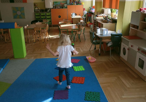 Dziewczynka chodzi po ścieżce snsorycznej