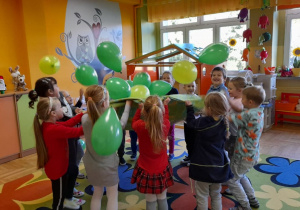 Dzieci bawią się podrzucając balony.