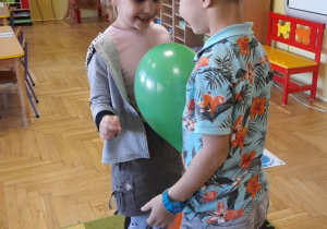 Jula i Filip tańczą z balonem.