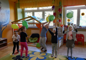 Dzieci podrzucają i chwytają swoje balony.