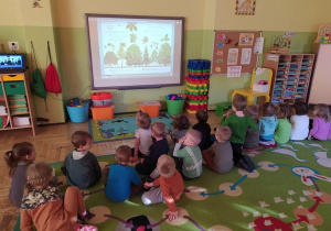 Dzieci oglądają prezentację związaną z Dniem Drzewa