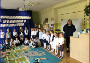 Dzieci z grupy Liski i Sówki elegancko ubrane stoją z panią Ewelina